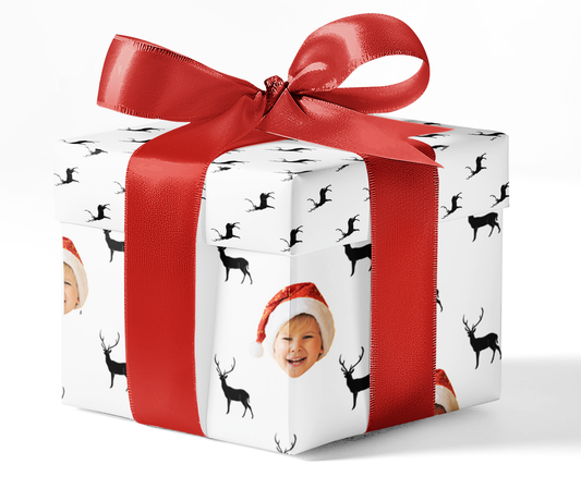 A gift wrapped in custom wrapping paper with a black and white deer pattern, adorned with a red ribbon.