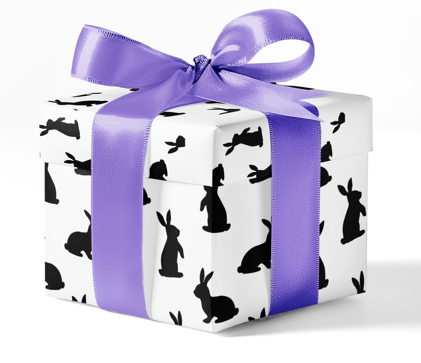 A gift box wrapped in black and white wrapping paper with a pattern of rabbits and rabbits holes, tied with a purple ribbon.