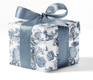 A gift box wrapped in custom blue toile print wrapping paper with a blue ribbon.