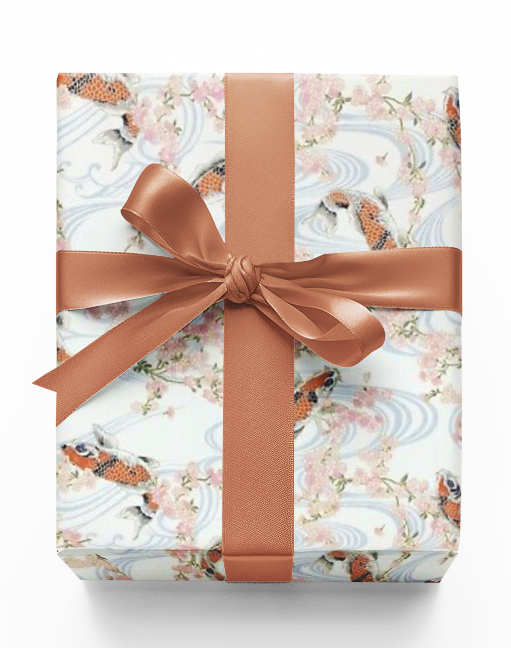 A wrapped gift box with custom Christmas-themed wrapping paper featuring a pattern with koi fish and flowers, tied with a bronze ribbon.