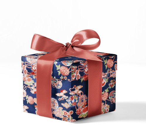 A box wrapped in custom wrapping paper with a floral pattern and a pink ribbon.