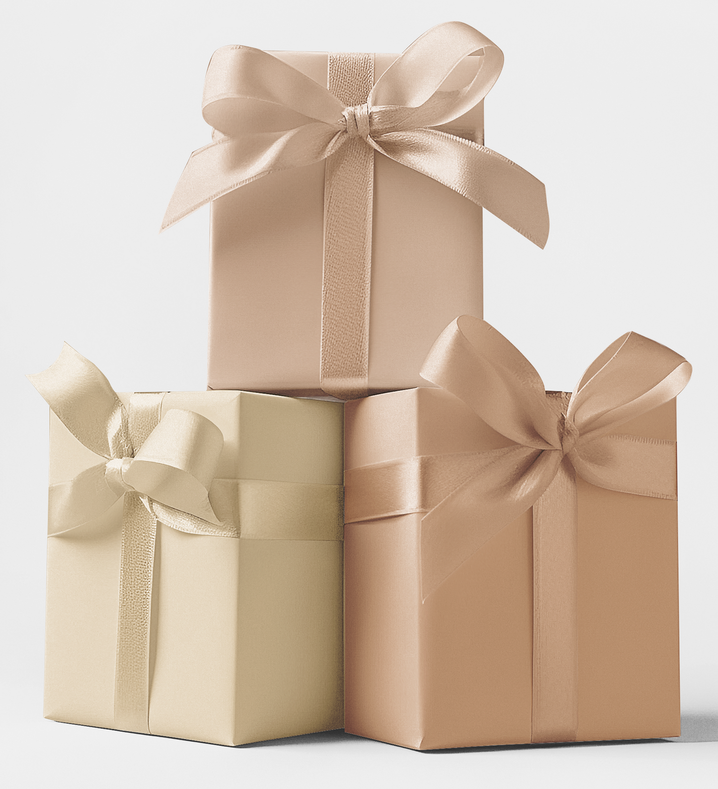 Three gift boxes in wrapping papers of Champagne Gold, Rose Gold, and Pale Blush colors, each box tied with a matching color ribbon.