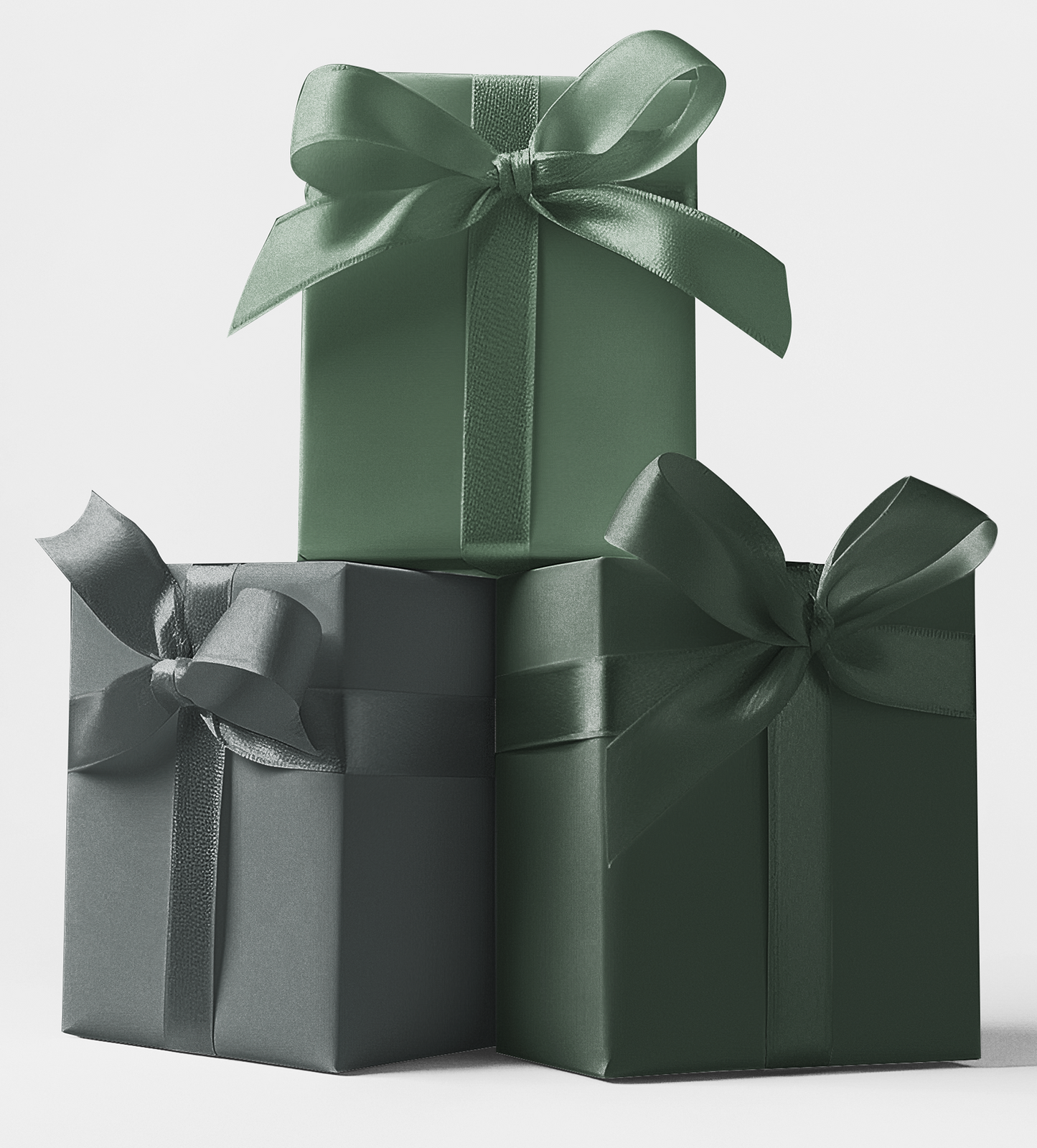 Three gift boxes stacked in order of size with ribbons, wrapped in green tones of wrapping paper.
