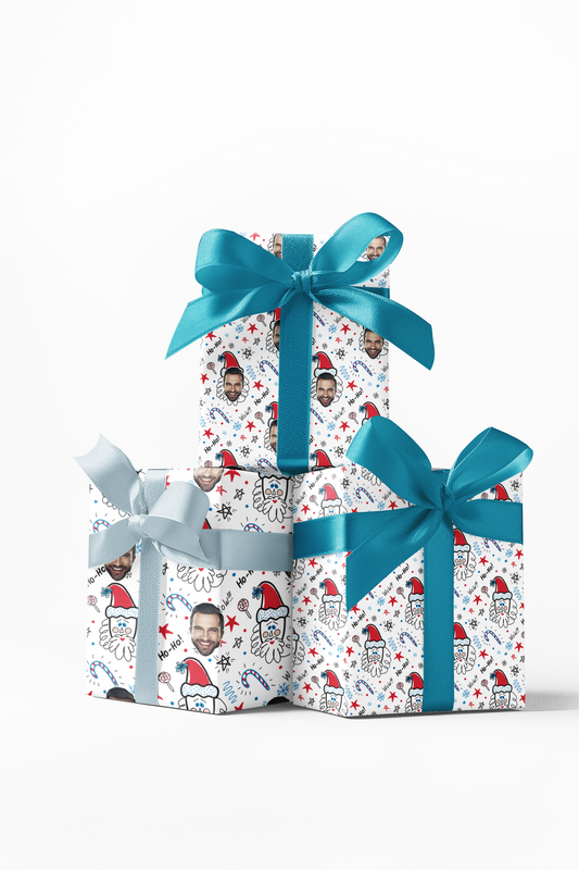 Stack of three wrapped gifts with custom wrapping paper featuring a white and red pattern with Santa Claus faces, and blue ribbons.