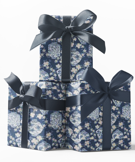 Stacked gift boxes wrapped in blue custom wrapping paper with a floral pattern and tied with a blue ribbon.