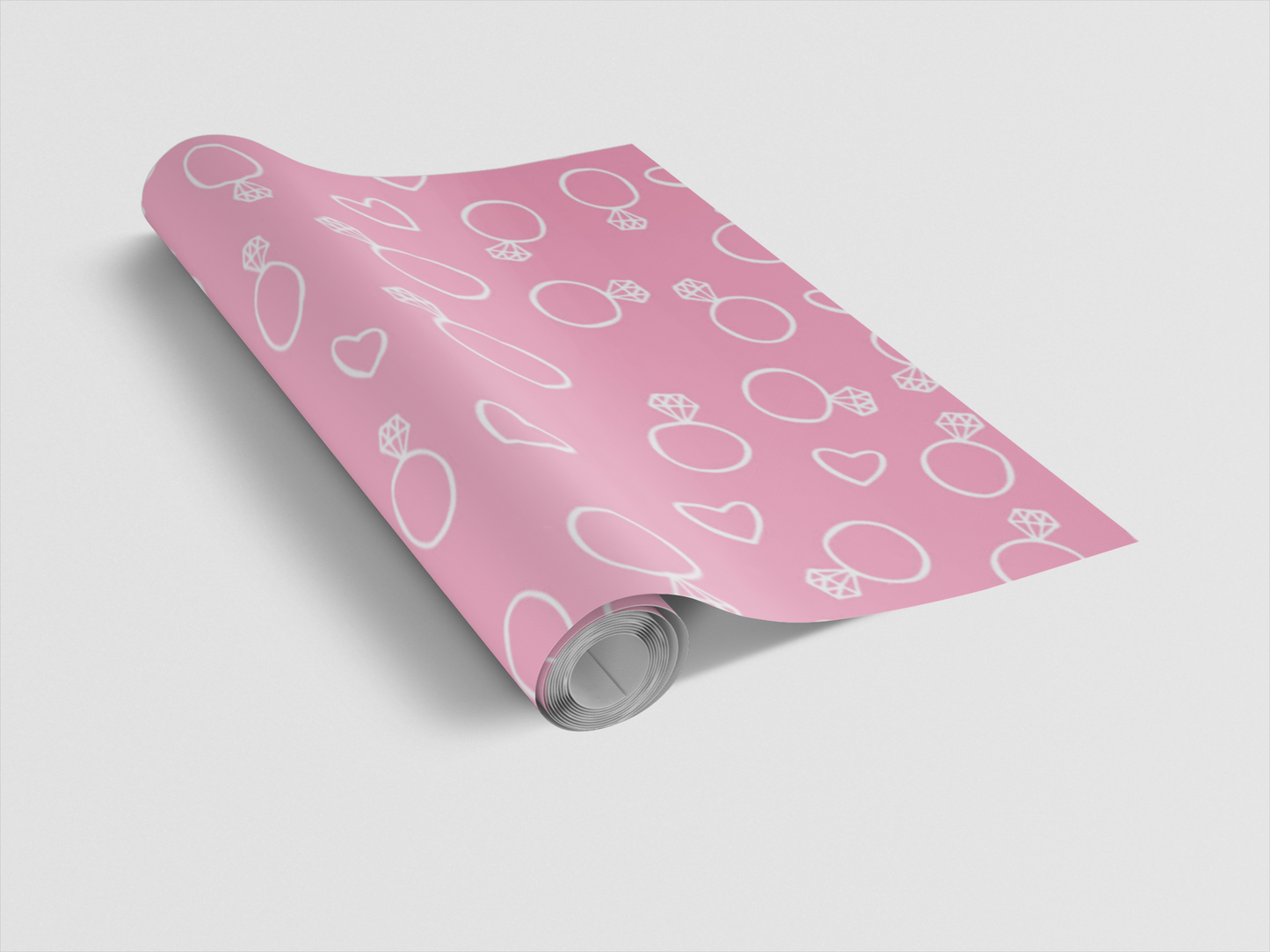 Roll of pink wrapping paper with white patterns on a light gray background