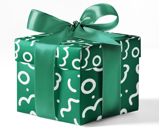 A gift box wrapped in green custom wrapping paper with a geometric pattern and tied with a ribbon.