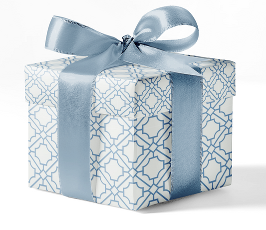 A gift box wrapped in custom wrapping paper with a blue geometric pattern and tied with a blue ribbon.