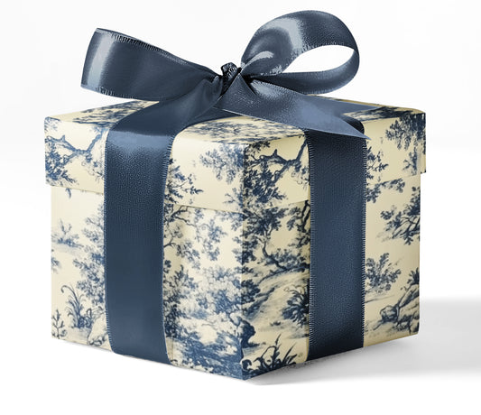 A gift box wrapped in custom wrapping paper with a blue and white toile pattern, tied with a blue ribbon.