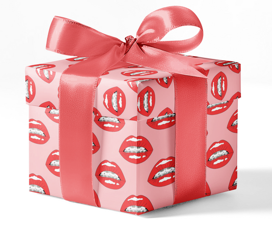A gift box wrapped in wrapping paper with a pattern of lips, tied with a red ribbon.