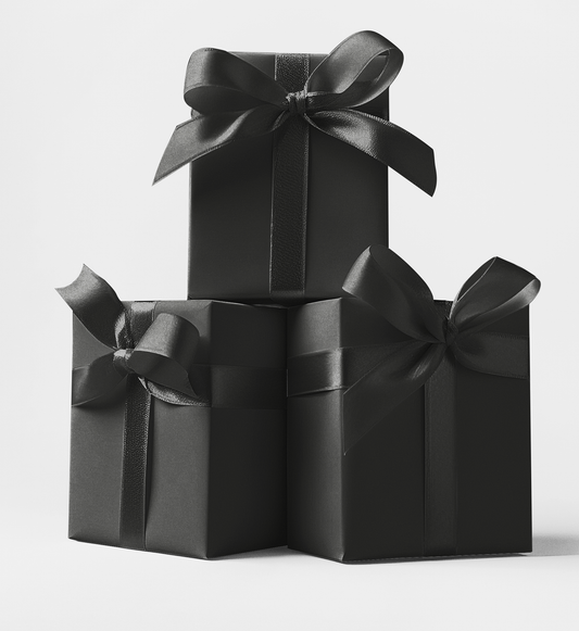 Three black gift boxes stacked in a triangular formation, each box tied with a black ribbon. Custom Wrapping paper available at custommyprints.com