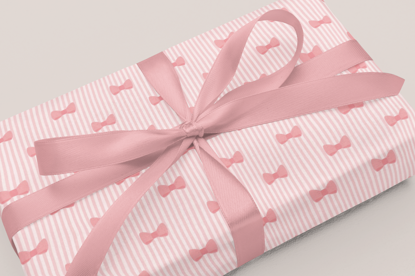 Gift wrapped in blue paper with moon patterns and a white ribbon on a light gray background