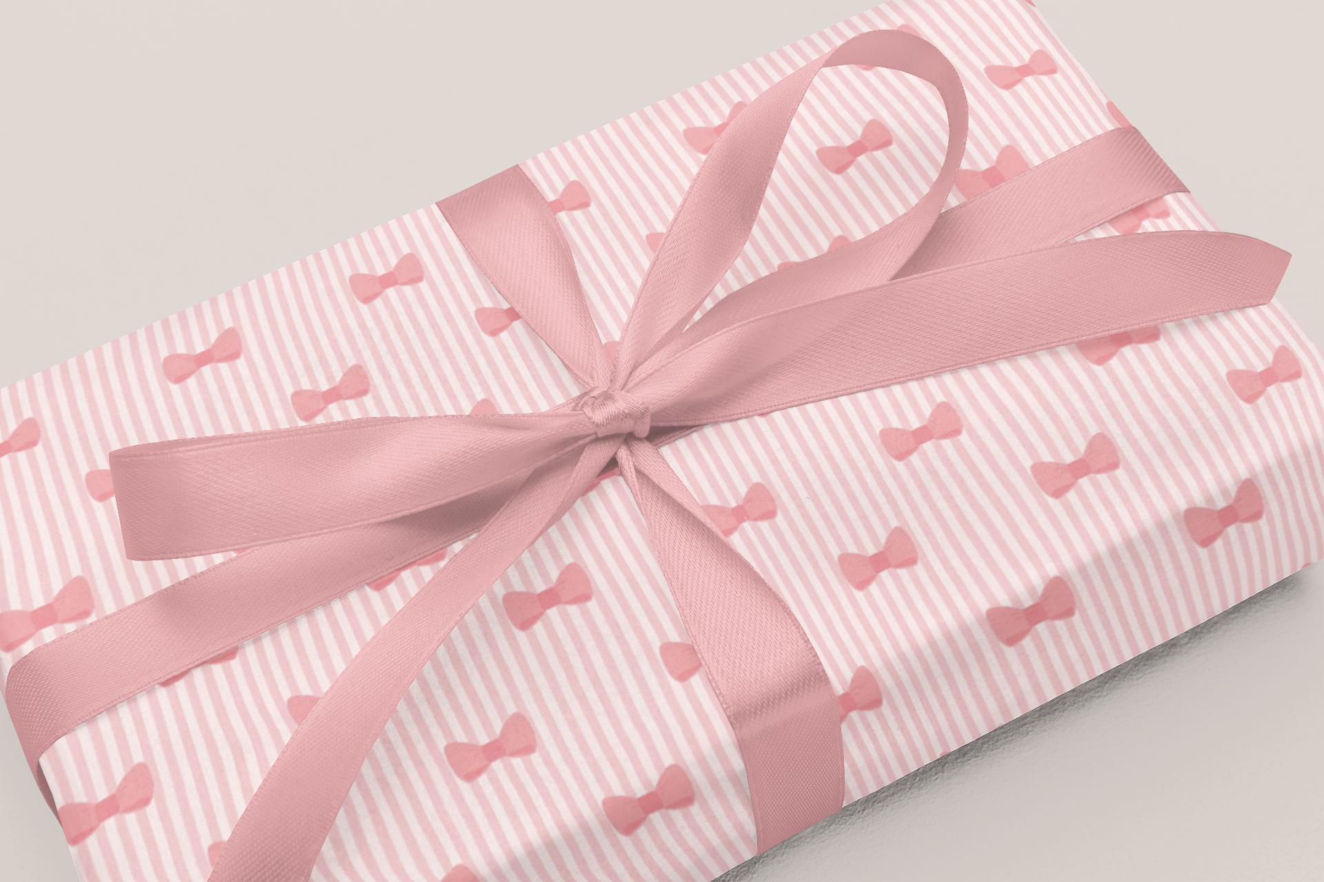 Gift wrapped in blue paper with moon patterns and a white ribbon on a light gray background
