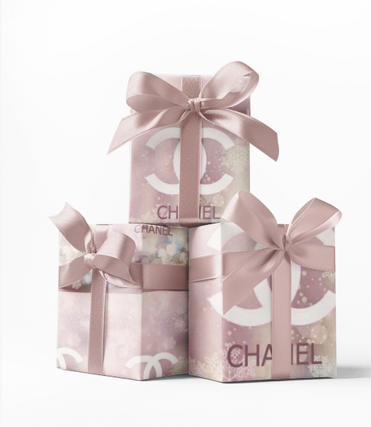 Stack of three custom wrapped gifts with pink and white Chanel print wrapping paper and pink ribbons.