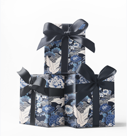 Stack of three gift boxes wrapped in blue and white patterned wrapping paper with black bows on top.