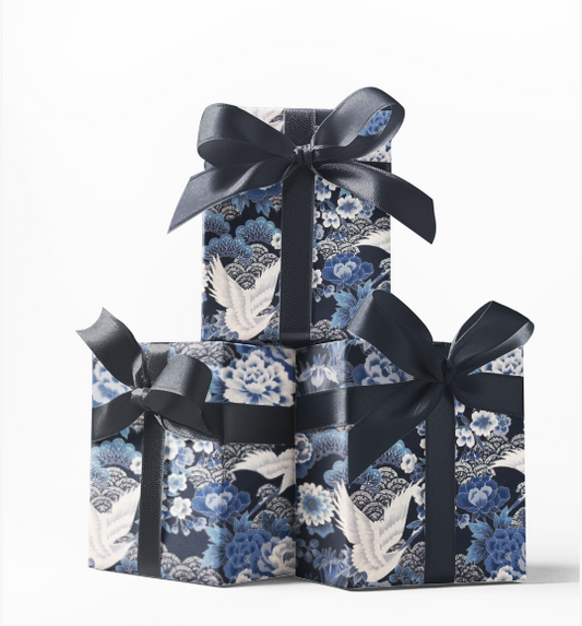 Stack of three gift boxes wrapped in blue and white patterned wrapping paper with black bows on top.