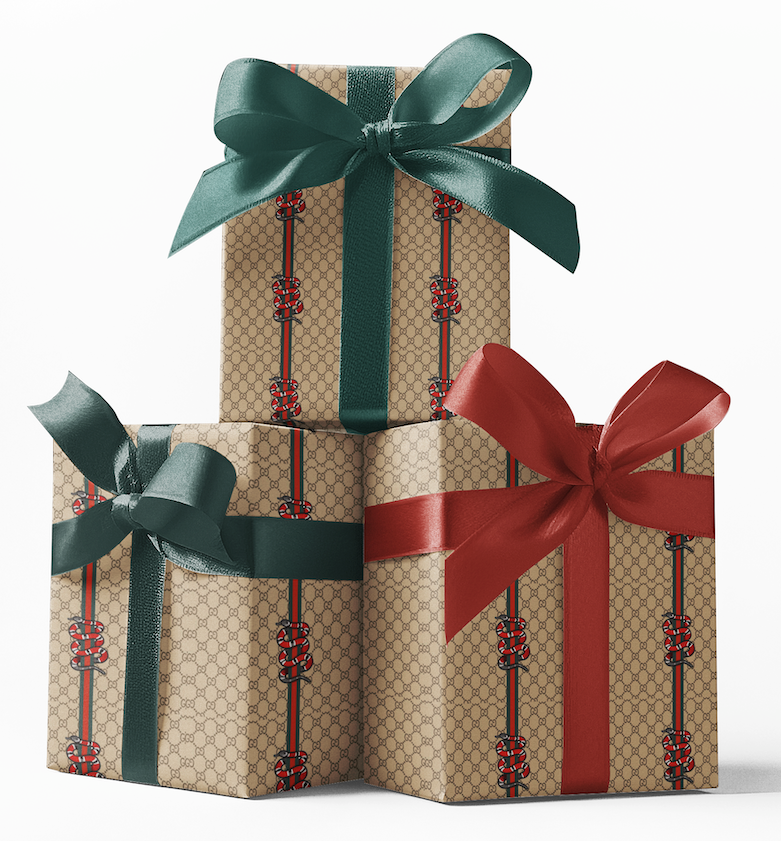 Stacked gift boxes wrapped in custom Gucci snake pattern wrapping paper with red and green bows.