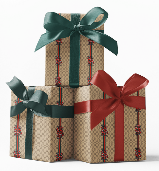Stacked gift boxes wrapped in custom Gucci snake pattern wrapping paper with red and green bows.