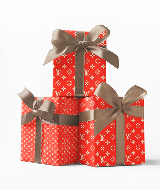 Stacked red gift boxes with a custom Louis Vuitton inspired wrapping paper pattern and a silver bow on top.