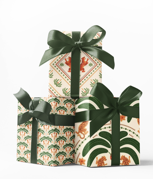 Stack of three gift boxes wrapped in green and white patterned wrapping paper with dark green ribbons.