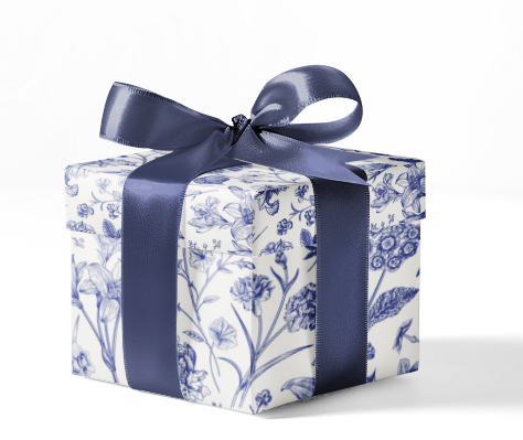 A gift box wrapped in custom wrapping paper with a blue and white floral pattern, tied with a blue ribbon.