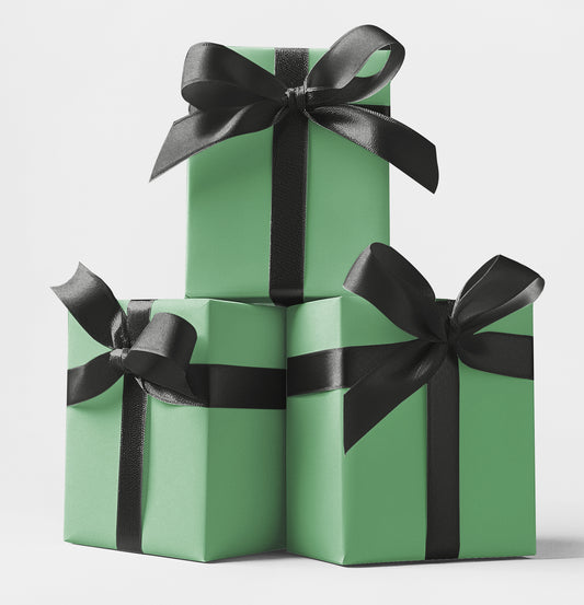 Three stacked gift boxes wrapped in green custom wrapping paper with sleek black satin ribbons – premium wrapping available at CustomMyPrints.com.