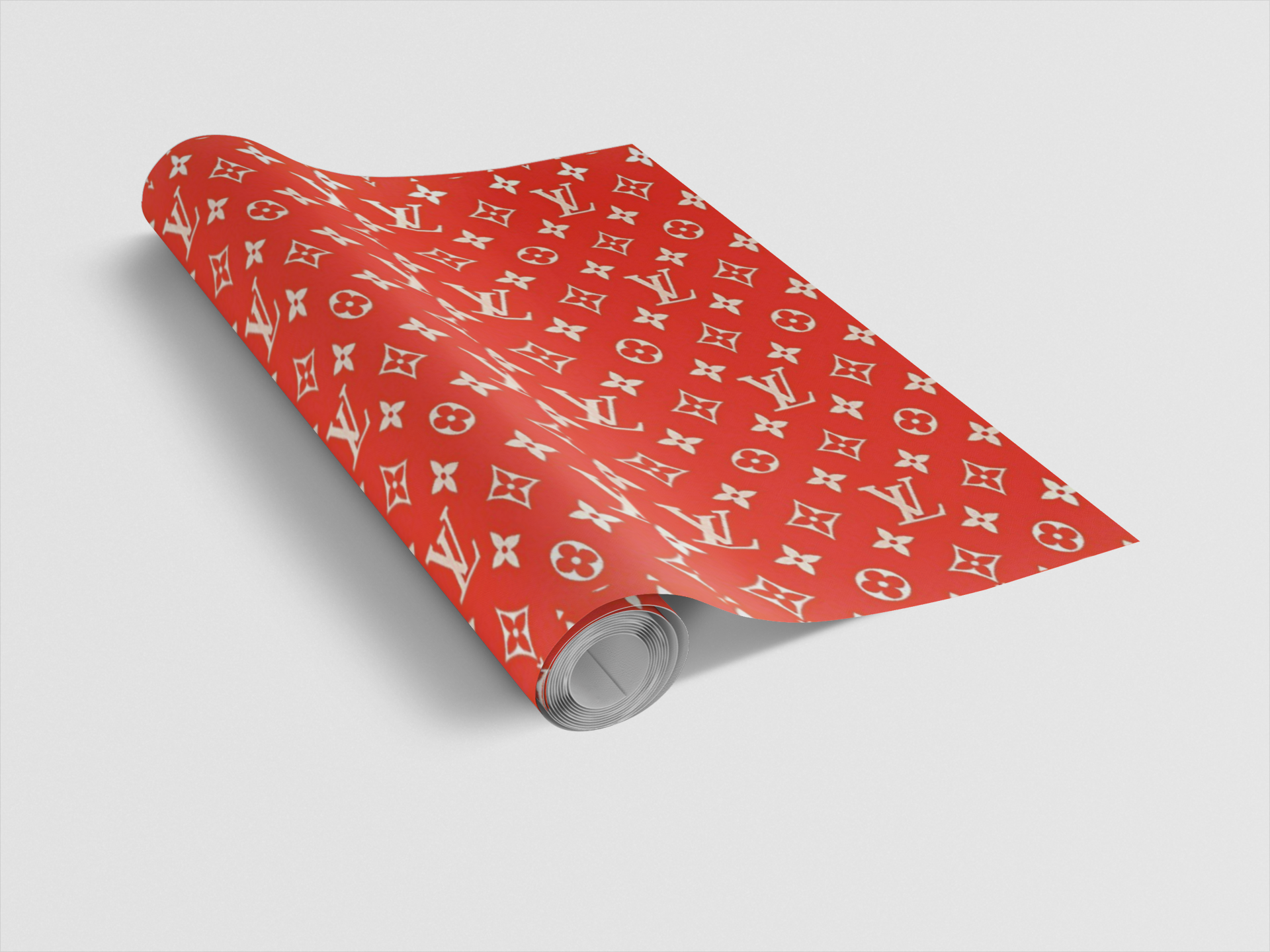 Roll of red wrapping paper with a white pattern on a light gray background
