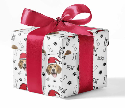 A custom wrapping paper with a design featuring a dog wearing a Santa hat, bones, and paws printed pattern. The paper is wrapped around a gift with a red ribbon on top.