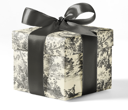 A gift box wrapped in custom grey toile wrapping paper with a black ribbon bow.