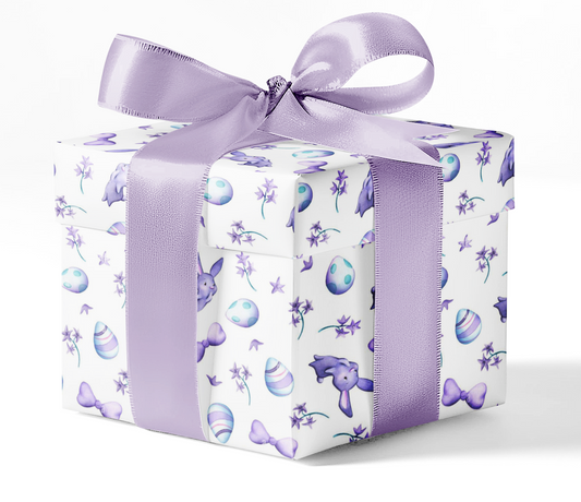 A gift box wrapped in custom wrapping paper with a floral pattern, predominantly in purple colors, tied with a purple ribbon.