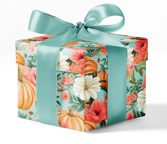 A gift box wrapped in custom wrapping paper with a floral and autumnal pattern, tied with a teal ribbon.