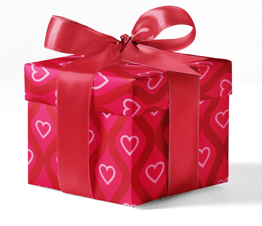 A gift box wrapped in red wrapping paper with a heart pattern and tied with a red ribbon.