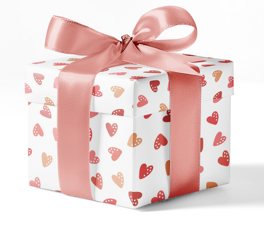 A gift box wrapped in customizable wrapping paper with a pattern of red and pink hearts, tied with a pink ribbon.