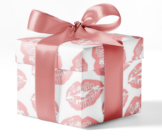 A gift box wrapped in custom wrapping paper with a pattern of lipstick marks and tied with a pink ribbon.