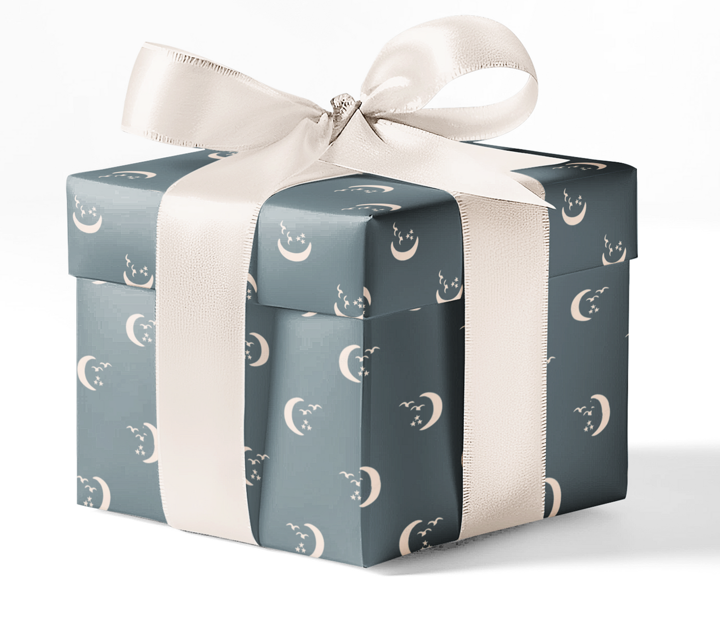 A gift box wrapped in custom wrapping paper with a pattern of moons and stars, tied with a white ribbon.