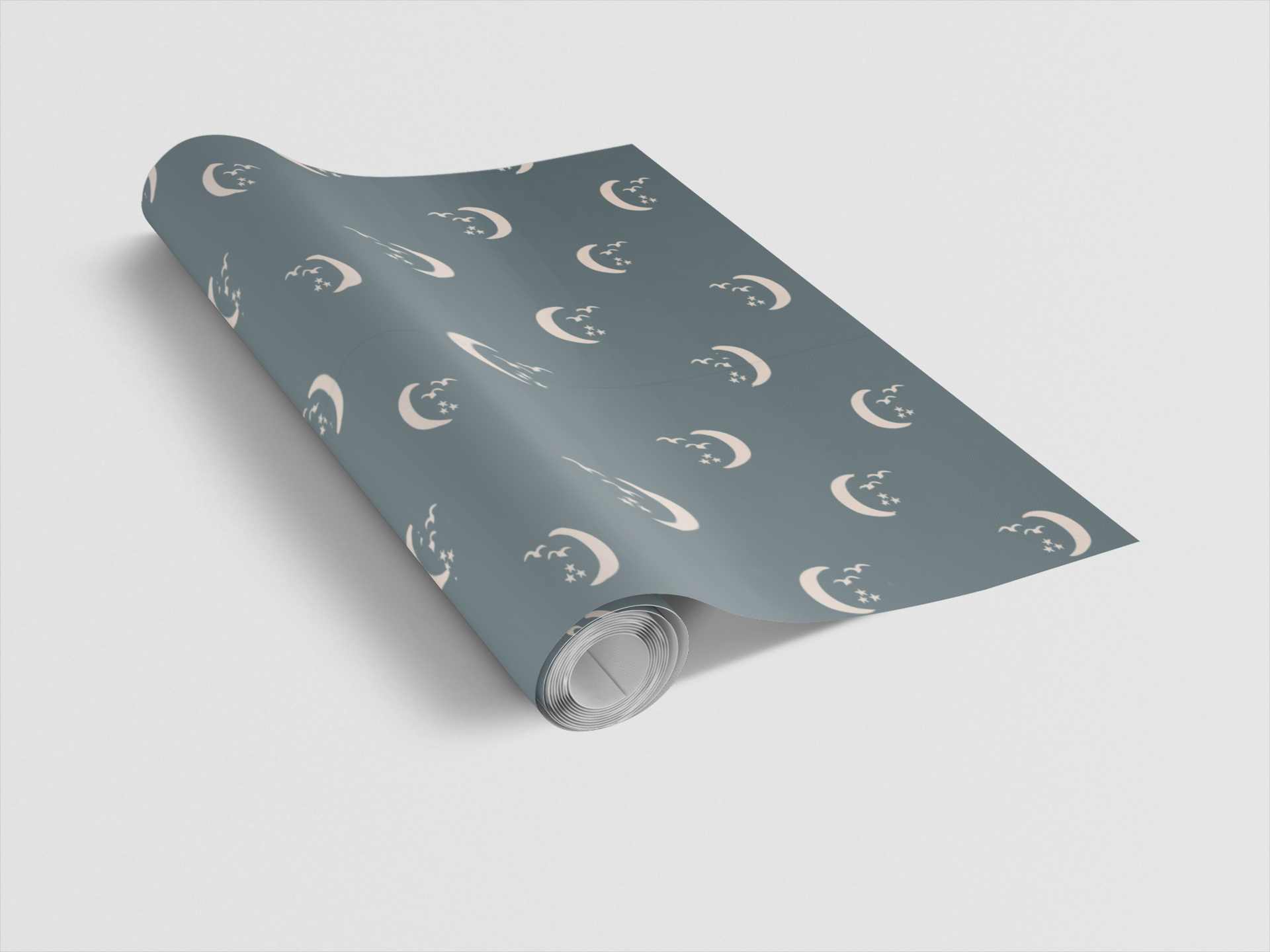 Roll of blue wrapping paper with moon and star pattern on a light gray background