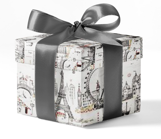A gift box wrapped in custom wrapping paper with a black and white Paris-themed pattern, including famous landmarks, tied with a grey ribbon.