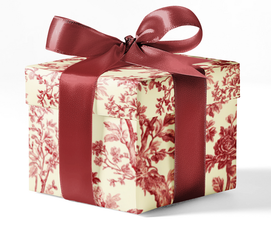 A gift box wrapped in custom red toile wrapping paper with a red ribbon.