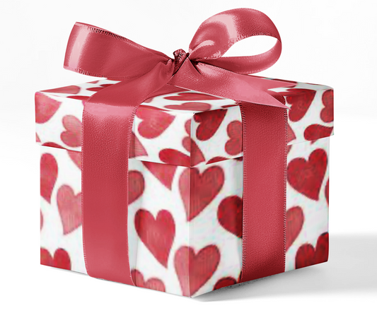 A gift box wrapped in wrapping paper with a red hearts pattern and tied with a red ribbon.