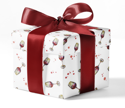 A gift box wrapped in custom wrapping paper with a pattern of wine glasses and colored splatters, tied with a red ribbon.