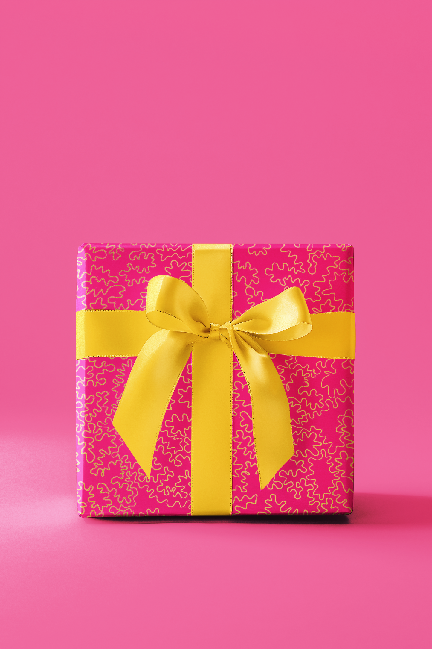 Pink gift box with yellow ribbon on a pink background